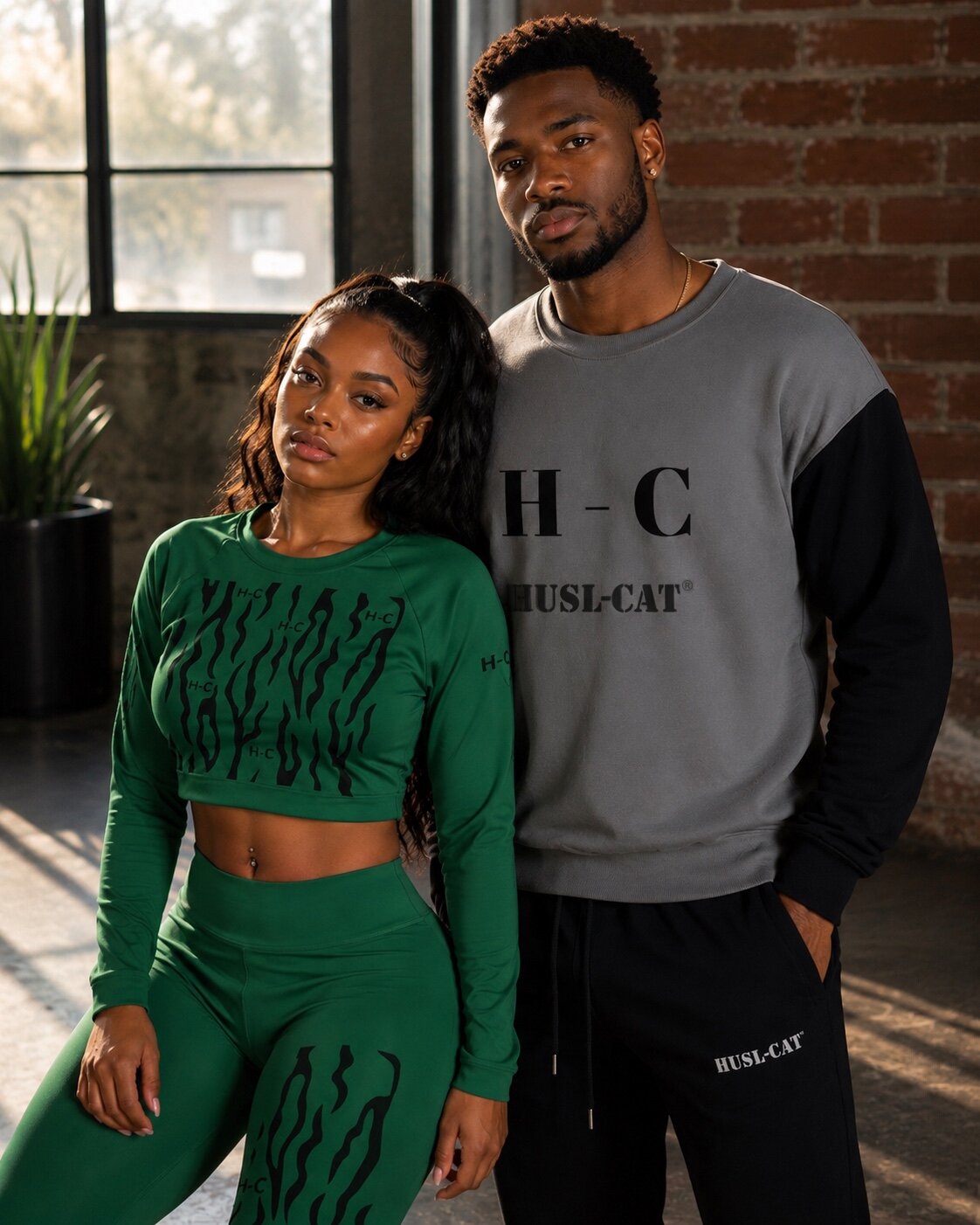 Woman in a green HUSL-CAT crop top beside a man in a gray HUSL-CAT sweatshirt