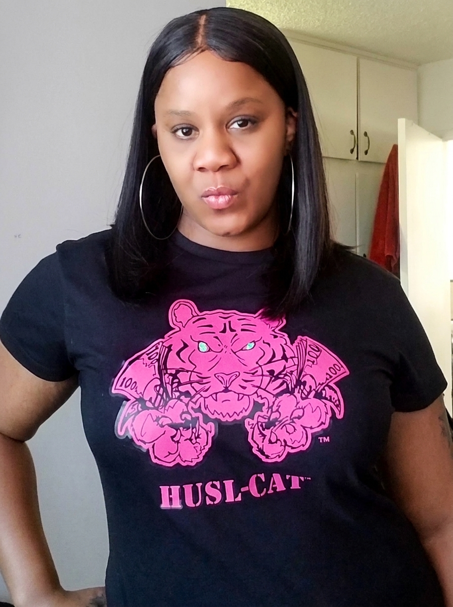 Woman wearing a black HUSL-CAT T-shirt with a pink tiger graphic